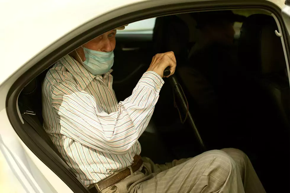 rentner krankentransport älterer Mann mit Gehstock steigt aus einem Auto aus